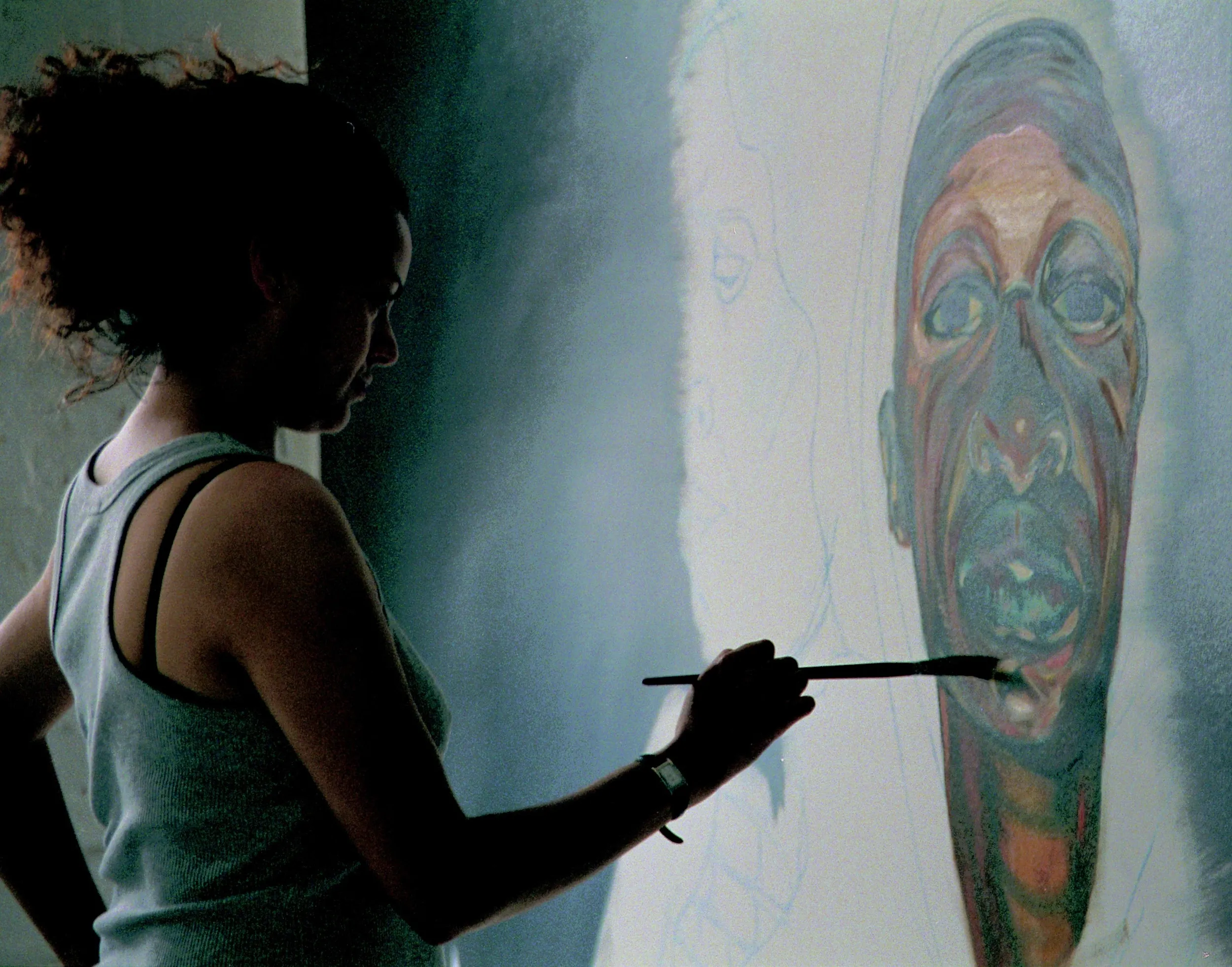 Helen Wilson Roe painting a colourful portrait in her studio at Mivart Street Studios, Bristol