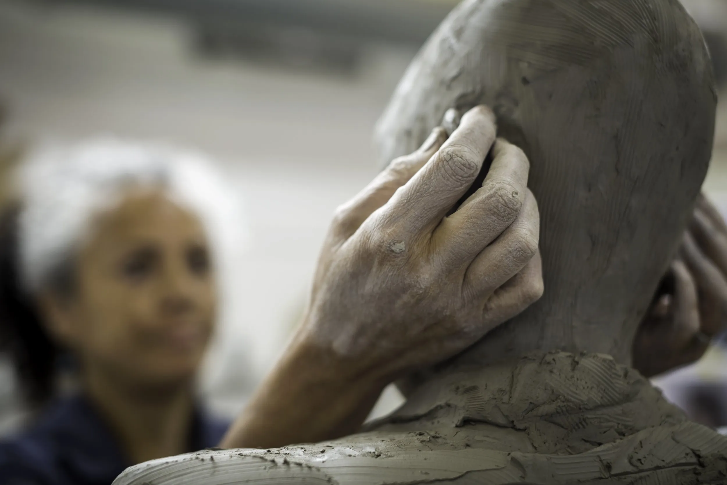 Helen Wilson Roe's hand shaping the clay head of a sculpture in progress