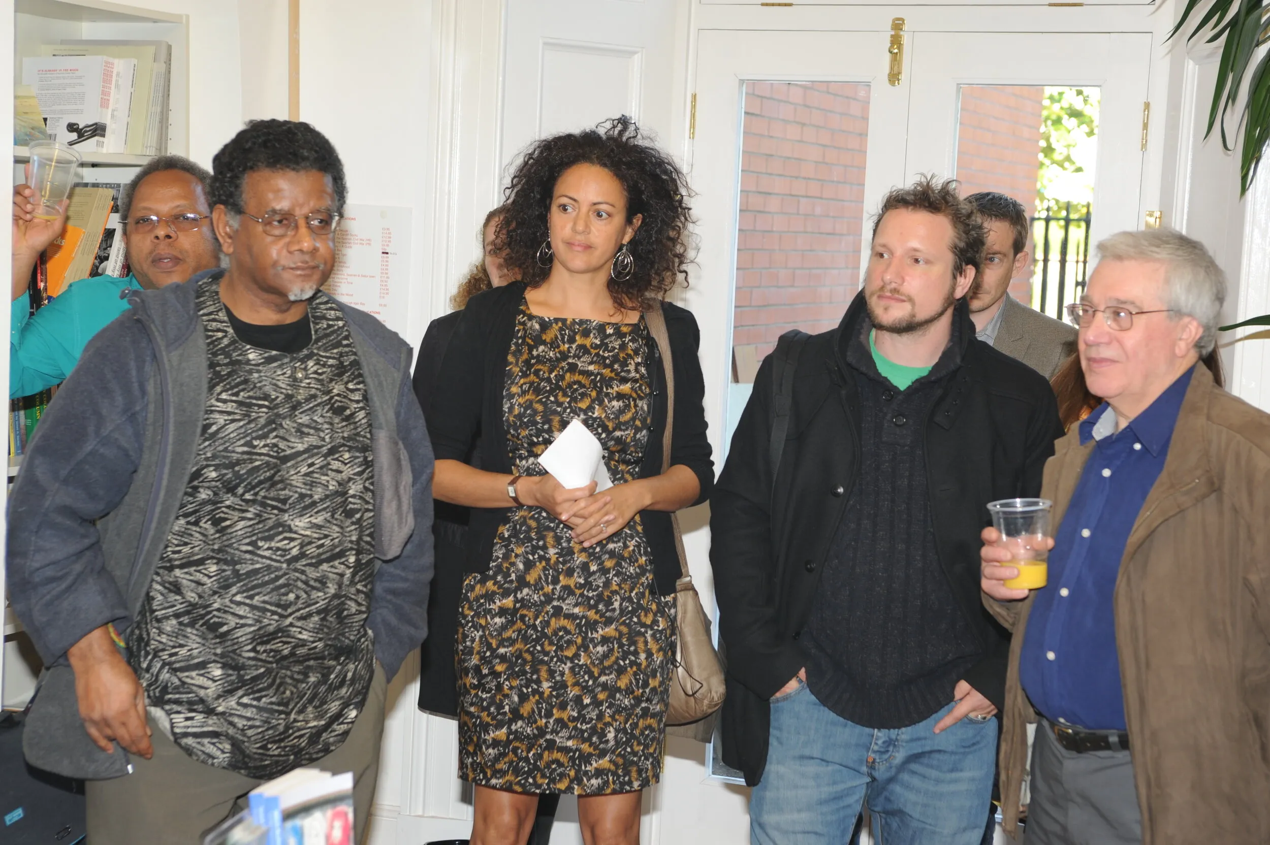 Group of exhibition visitors gathered near a doorway at the private view