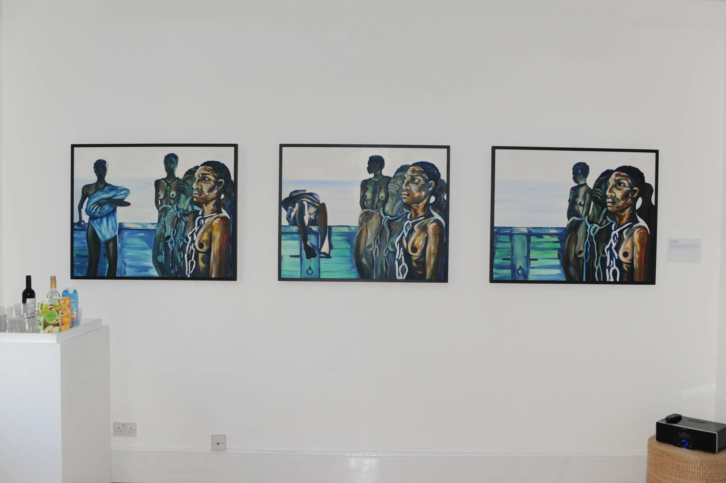 Triptych of oil paintings on a gallery wall depicting shackled Black figures at a ship's rail against the sea, evoking the transatlantic slave trade