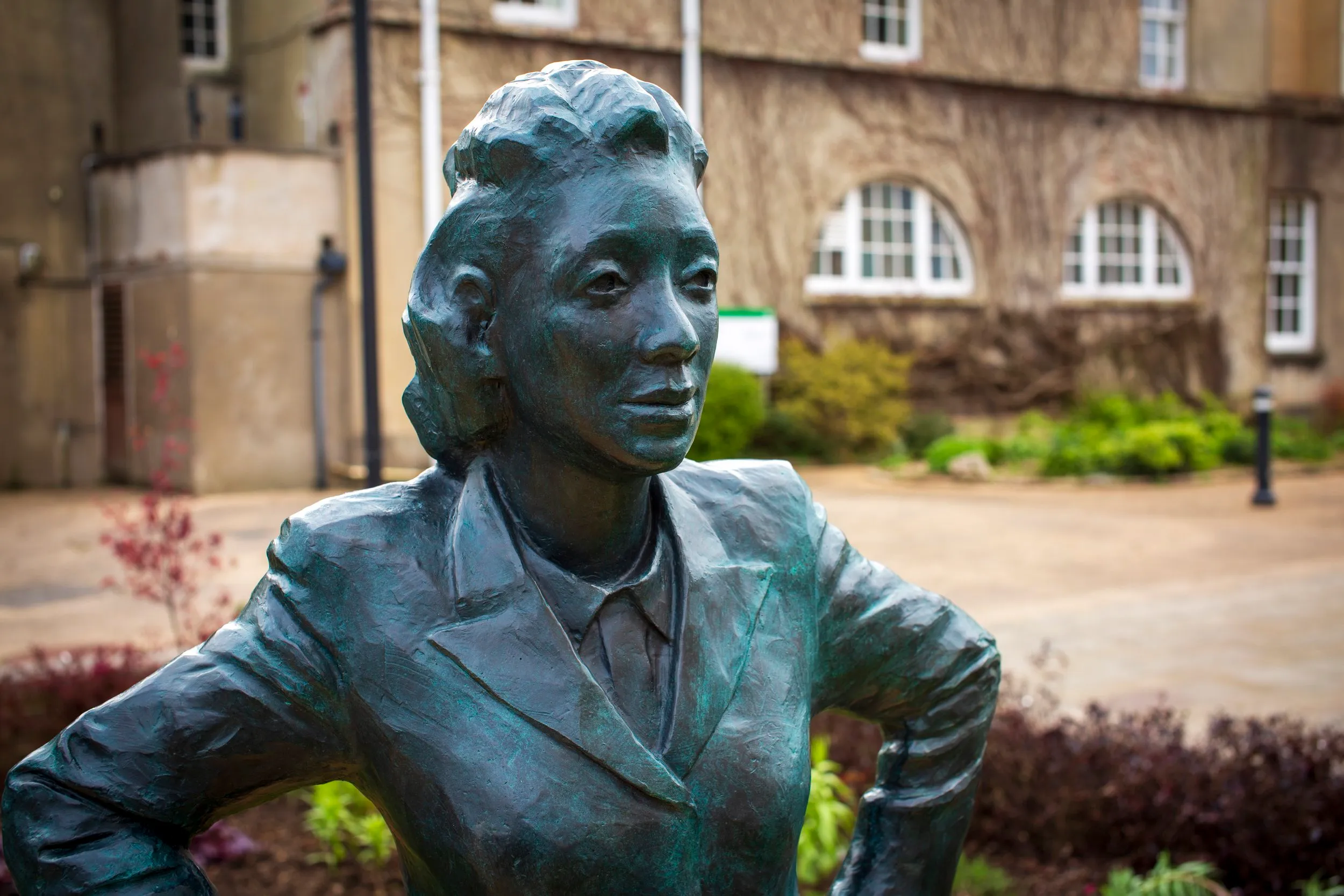 Close three-quarter view of the bronze Henrietta Lacks statue, showing her face and jacket in detail